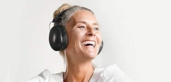 Photo d'une femme souriante portant un casque sur les oreilles